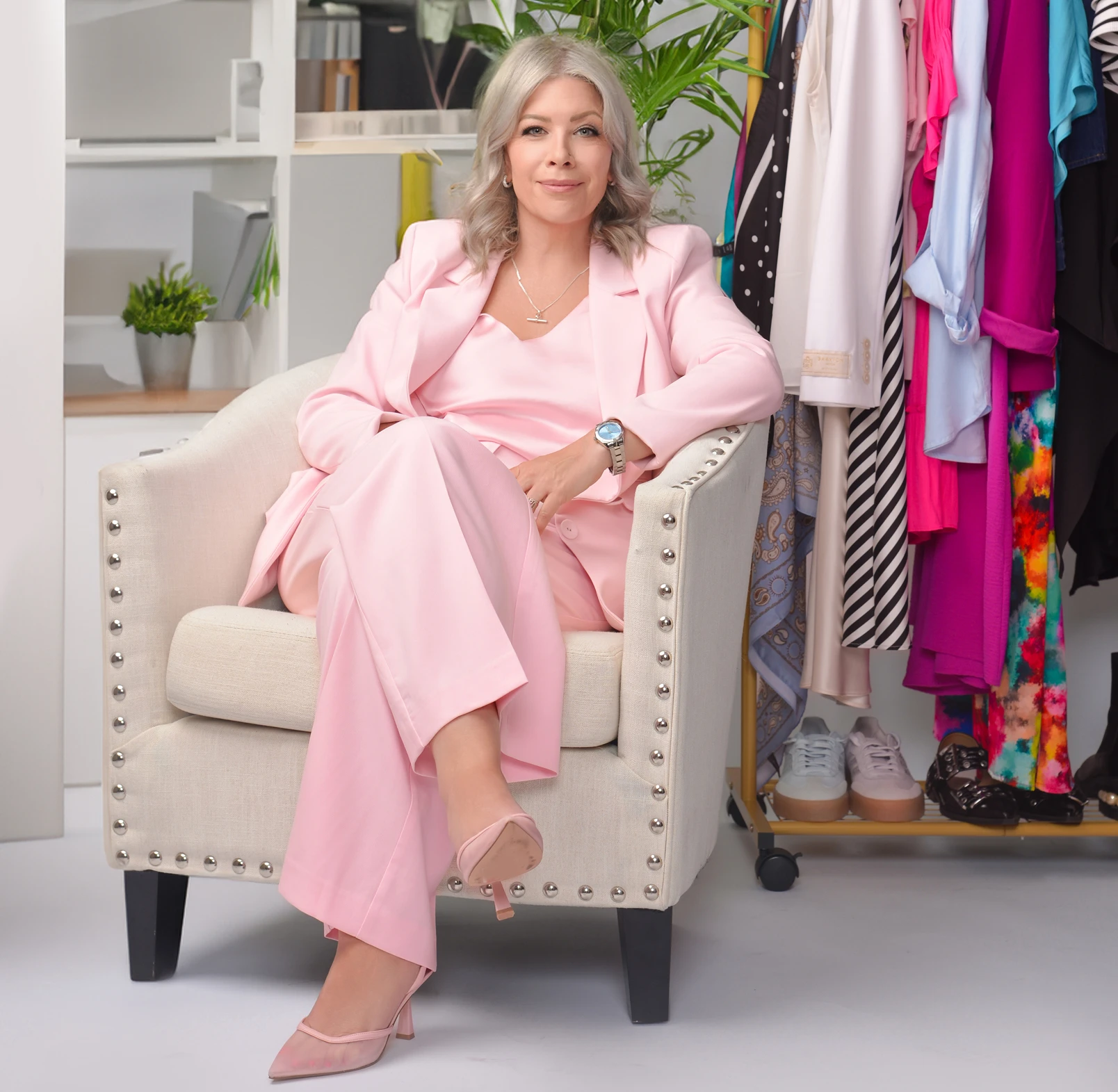 Woman in pink suit sitting confidently